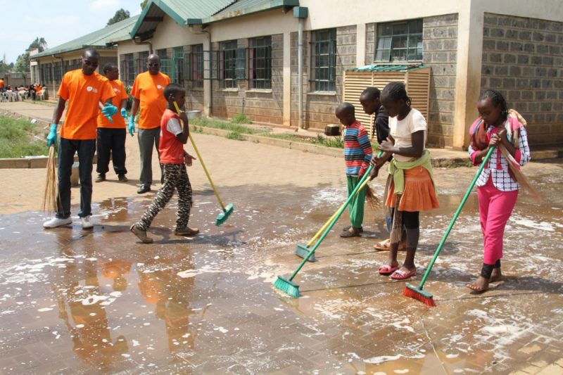 GSK team and the children cleaning the path ways