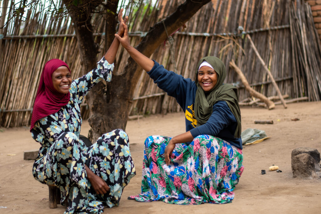 Asha Salum, (Left in maroon head wrap) out-of-school AGYW peer educator in Kondoa Dodoma region (Right her young sister). © For Amref Health Africa Tanzania.